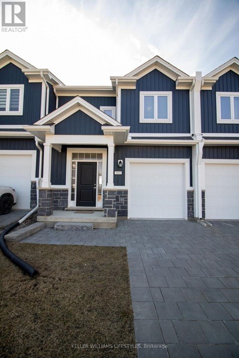 A modern house with a dark blue exterior and white trim.