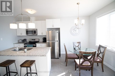 A kitchen with a table and chairs.