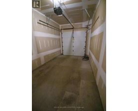 A spacious garage with a concrete floor and white walls.