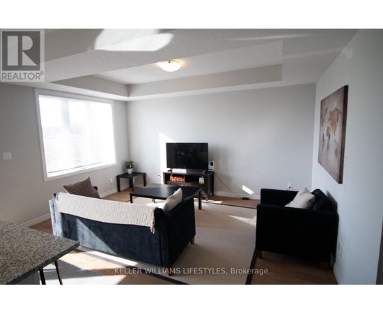 A living room with a black couch and a television.