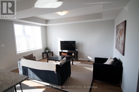 A living room with a black couch and a television.