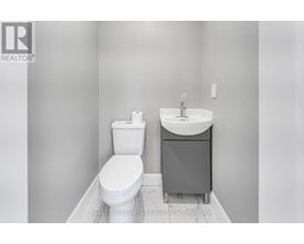 A white toilet and sink in a bathroom.