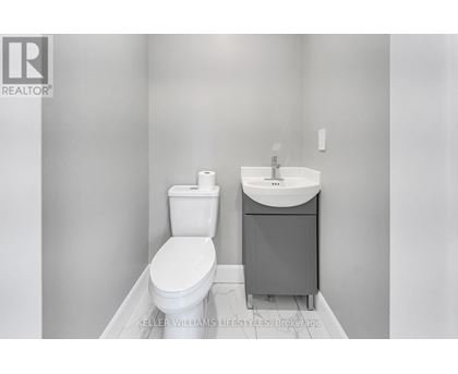 A white toilet and sink in a bathroom.