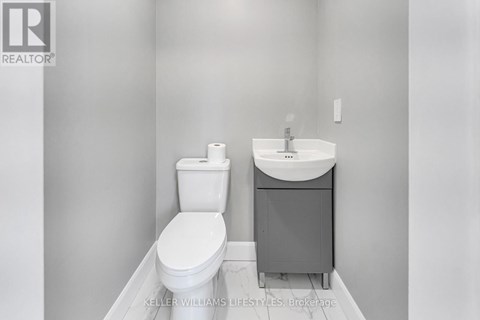 A white toilet and sink in a bathroom.