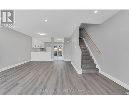 A spacious living room with a staircase leading to the upper floor.