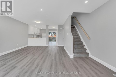 A spacious living room with a staircase leading to the upper floor.