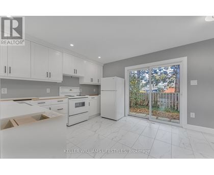 A kitchen with white cabinets and appliances is on the market.