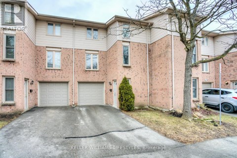 A large pink brick house with a white garage door.
