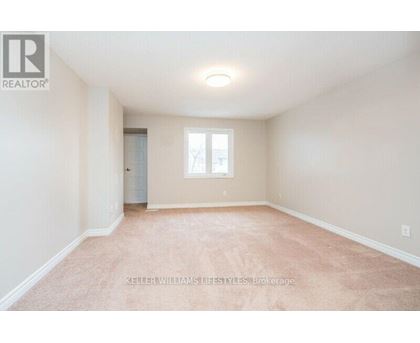 A spacious room with a carpeted floor and a window.