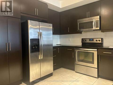 A kitchen with a stainless steel refrigerator and oven.