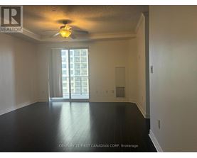 A spacious room with a ceiling fan and sliding glass doors leading to a balcony.