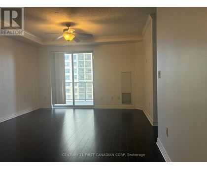A spacious room with a ceiling fan and sliding glass doors leading to a balcony.