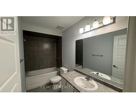 A bathroom with a tub, toilet, and sink.