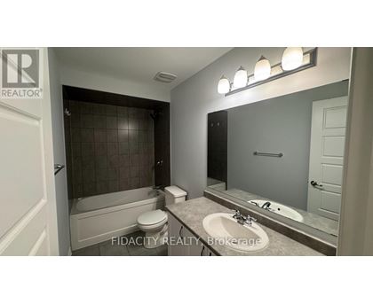 A bathroom with a tub, toilet, and sink.