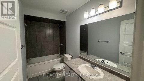 A bathroom with a tub, toilet, and sink.