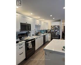 A well-lit, modern kitchen with white cabinets and a central island.
