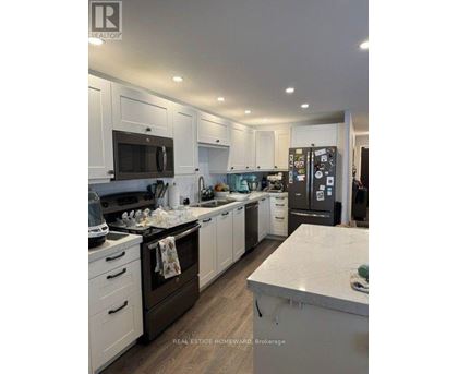 A well-lit, modern kitchen with white cabinets and a central island.