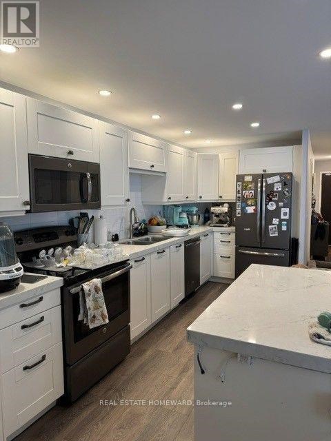 A well-lit, modern kitchen with white cabinets and a central island.