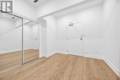 A room with a sliding door and wood flooring.