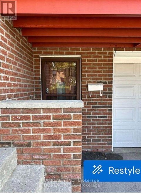 A brick wall with a white door and a window.