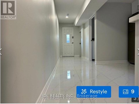 A hallway with a white marble floor and a door at the end.