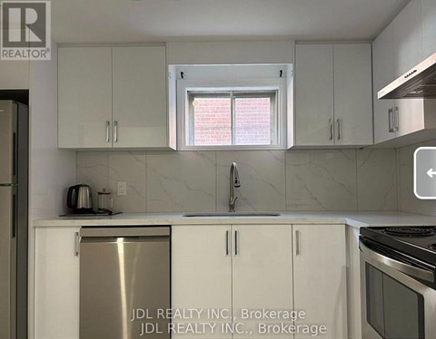 A kitchen with white cabinets and a stainless steel refrigerator.
