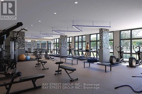 A gym with a variety of equipment including weights and benches.