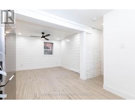A white room with a ceiling fan and wooden flooring.