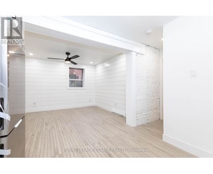 A white room with a ceiling fan and wooden flooring.
