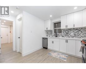 A kitchen with white cabinets and a patterned backsplash.
