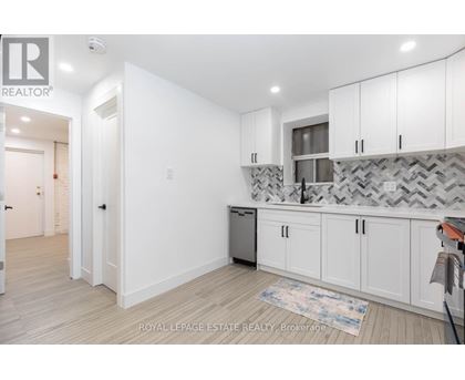 A kitchen with white cabinets and a patterned backsplash.