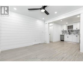 A spacious room with a ceiling fan and lighting fixtures.