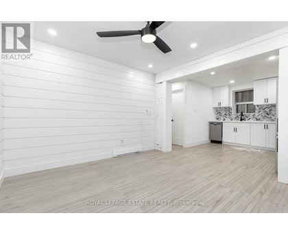 A spacious room with a ceiling fan and lighting fixtures.