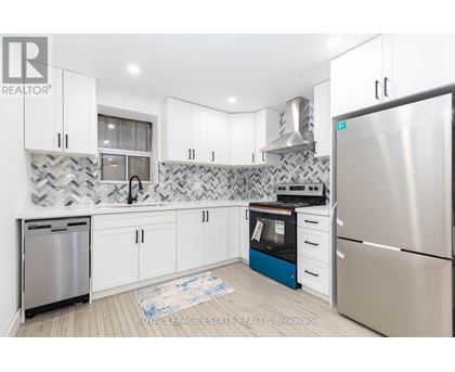 A kitchen with white cabinets and a patterned backsplash.