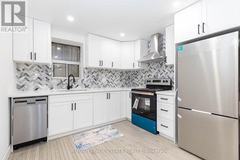 A kitchen with white cabinets and a patterned backsplash.