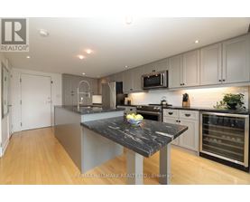 A modern kitchen with a marble island in the center.