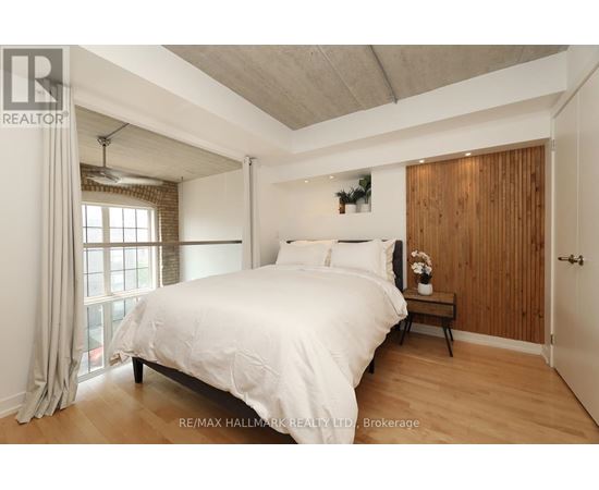 A bedroom with a large bed and a window with curtains.