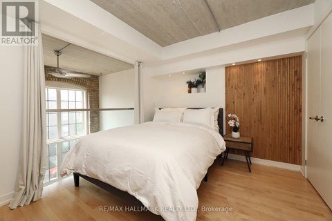 A bedroom with a large bed and a window with curtains.
