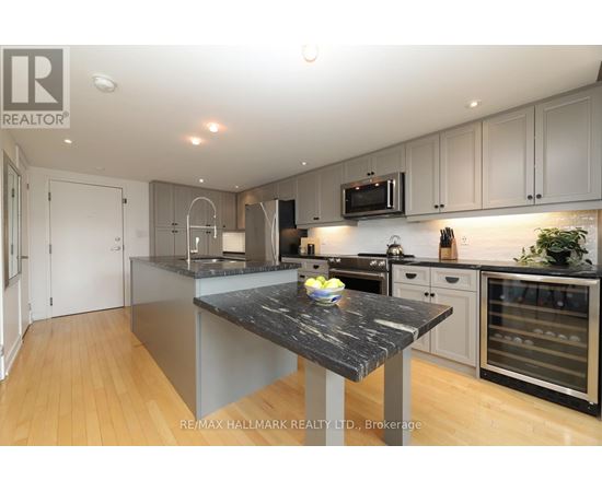 A modern kitchen with a marble island in the center.
