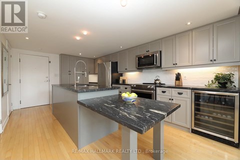 A modern kitchen with a marble island in the center.