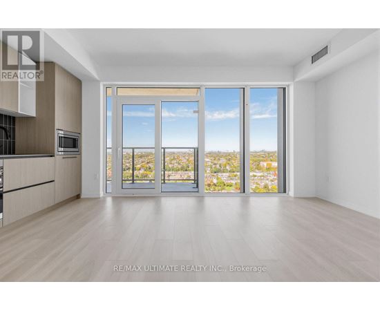 A spacious room with a view of the city through large windows.