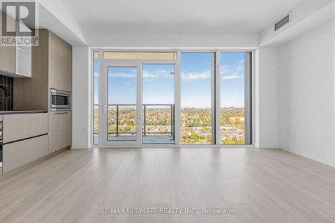 A spacious room with a view of the city through large windows.