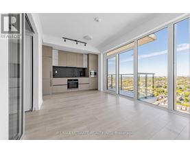 A spacious living room with a view of the cityscape outside the large windows.