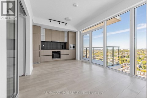 A spacious living room with a view of the cityscape outside the large windows.
