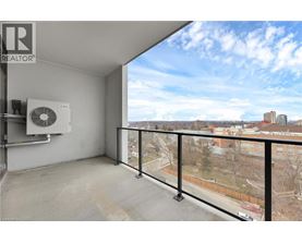 A balcony with a view of a cityscape and a window with a fan.