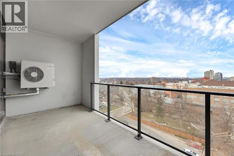 A balcony with a view of a cityscape and a window with a fan.
