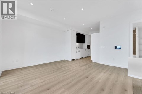 A spacious room with wooden flooring and white walls.