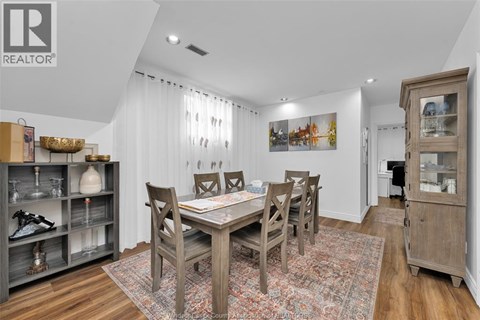 A dining room with a wooden table and chairs.