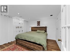 A bedroom with a bed and a rug on the floor.