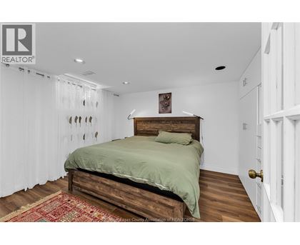 A bedroom with a bed and a rug on the floor.